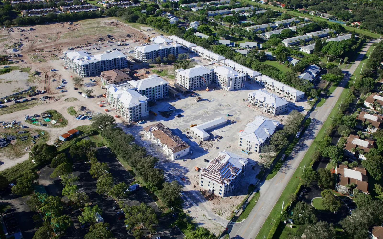 Aerial view of an active Florida multifamily construction site with buildings at different stages of progress.